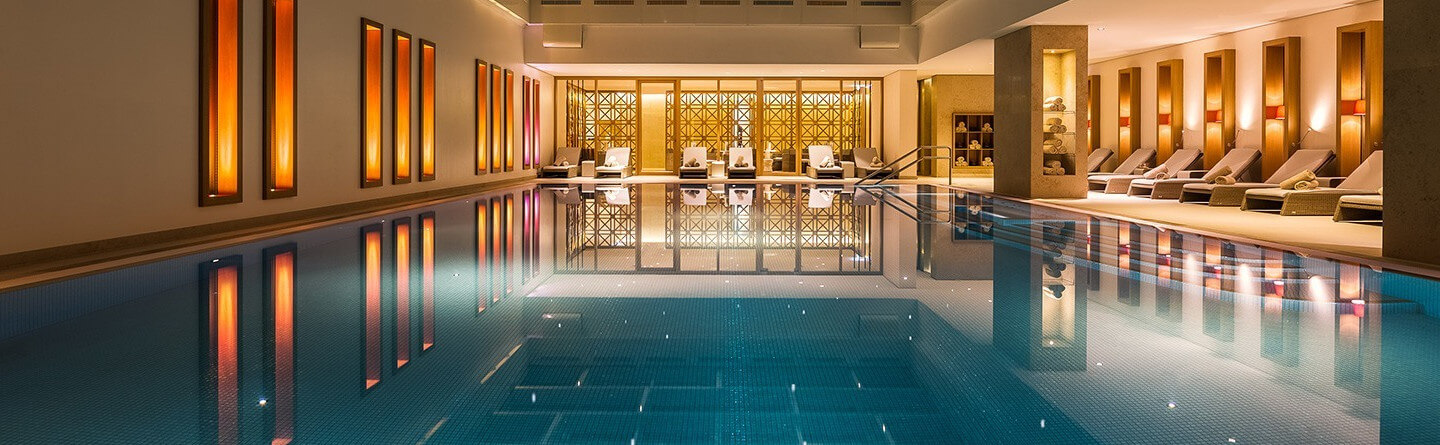 Das luxuriösen Schwimmbad des Severin*s Resort & Spa am Abend mit Blick auf den Ruhebereich