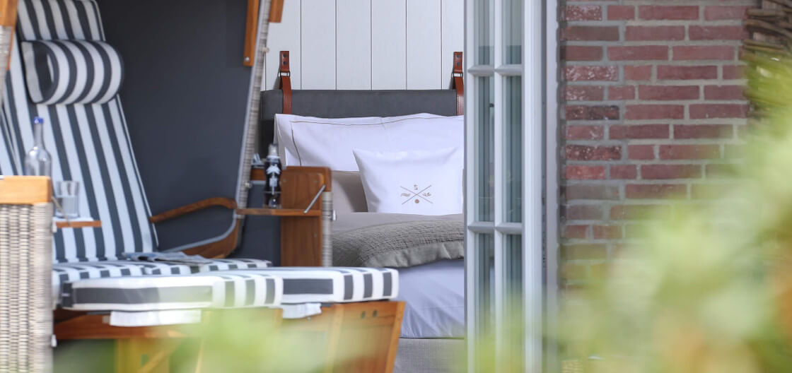 Blick in das Garden Landhaus-Zimmer von der eigenen Terrasse mit Strandkorb