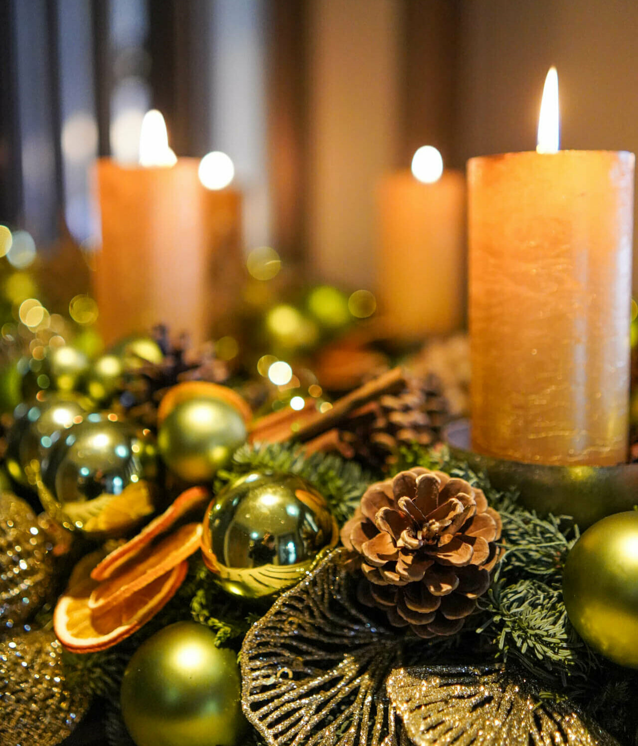 Festliche Dekoration mit brennenden Kerzen, Tannenzapfen und goldenen Kugeln im Hotel Landhaus Severin*s Morsum Kliff.