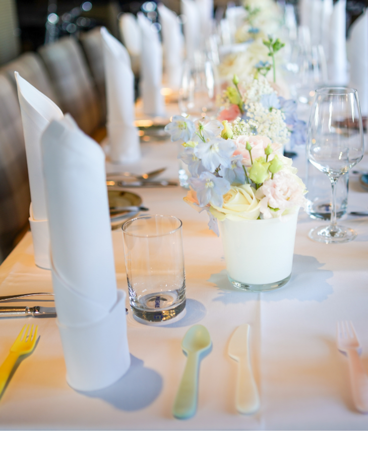 Elegante Tischdekoration mit weißen Servietten, Blumenarrangement und Gläsern im Hotel Landhaus Severin*s Morsum Kliff.