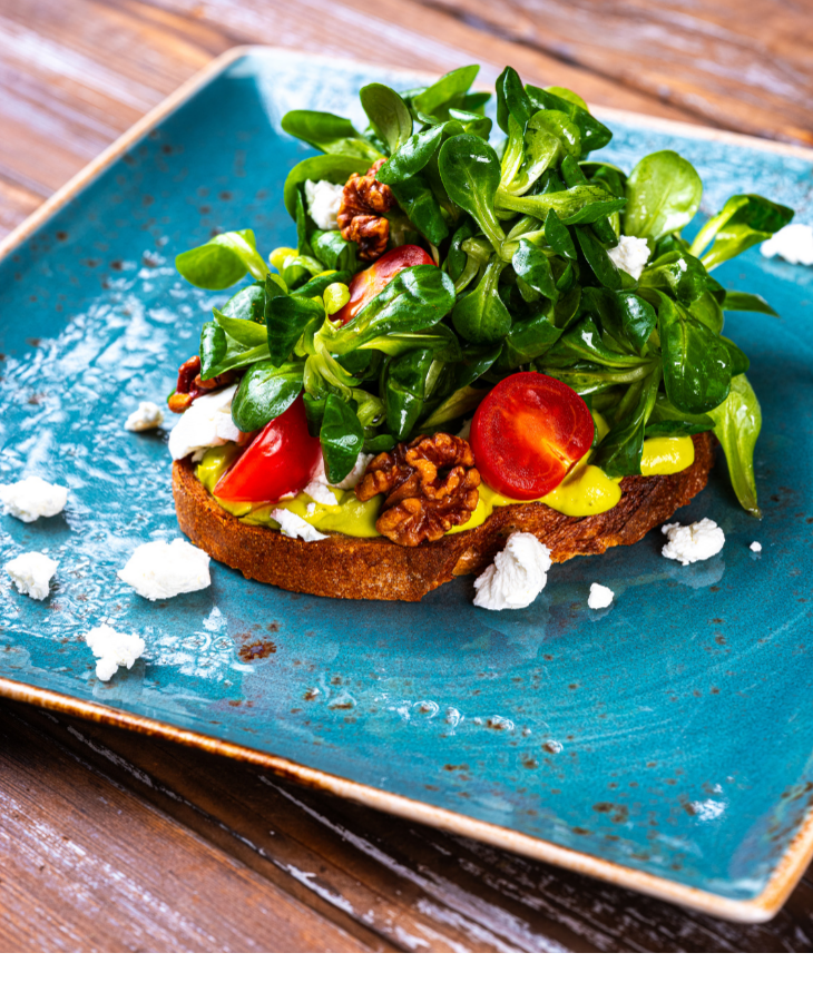 Vollkornbrot mit Avocado, Feldsalat, Tomaten, Walnüssen und Feta auf blauem Teller im Landhaus Severin*s Morsum Kliff.