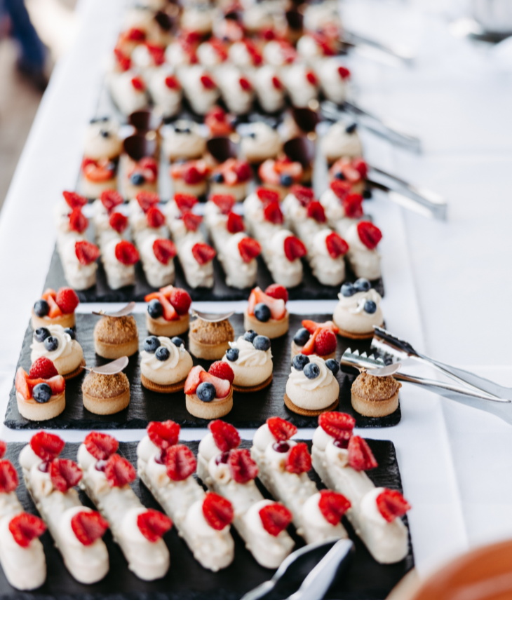 Eine Auswahl an kunstvoll dekorierten Desserts mit Beeren auf einem Buffet im Landhaus Severin*s Morsum Kliff.