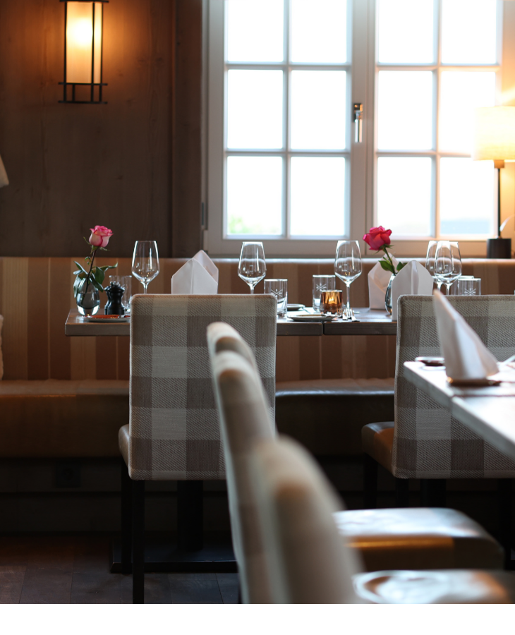 Gemütliches Restaurant mit gedeckten Tischen, Kerzenlicht und Blumen, im Landhaus Severin*s Morsum Kliff auf Sylt.