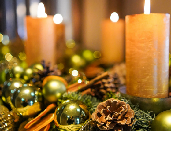 Festliche Dekoration mit brennenden Kerzen, Tannenzapfen und goldenen Kugeln im Hotel Landhaus Severin*s Morsum Kliff.
