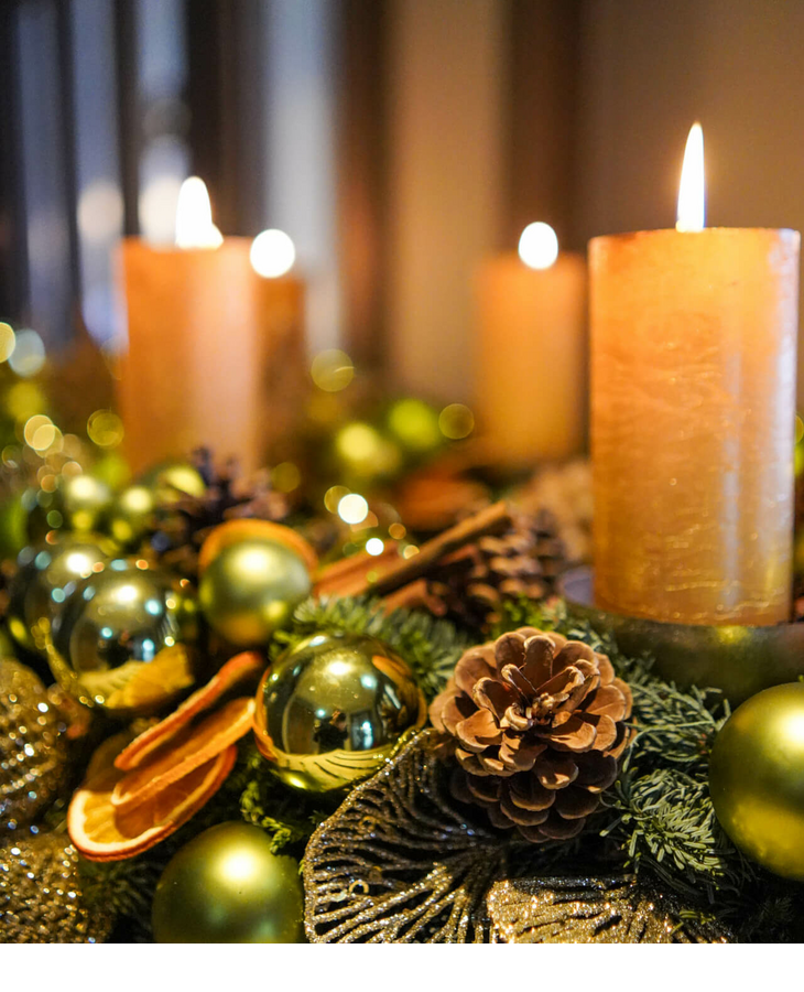 Festliche Dekoration mit brennenden Kerzen, Tannenzapfen und goldenen Kugeln im Hotel Landhaus Severin*s Morsum Kliff.