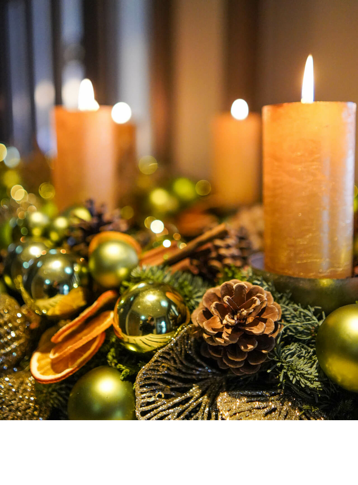 Festliche Dekoration mit brennenden Kerzen, Tannenzapfen und goldenen Kugeln im Hotel Landhaus Severin*s Morsum Kliff.