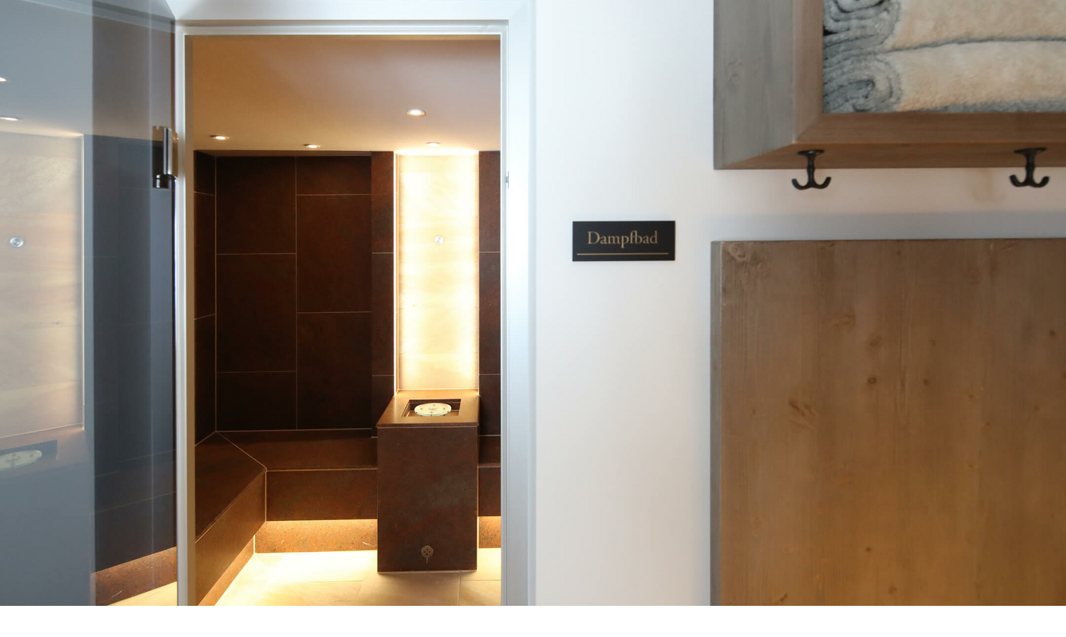Eingang zum Dampfbad im Landhaus Severin*s Morsum Kliff, mit Holzregal und Handtüchern.