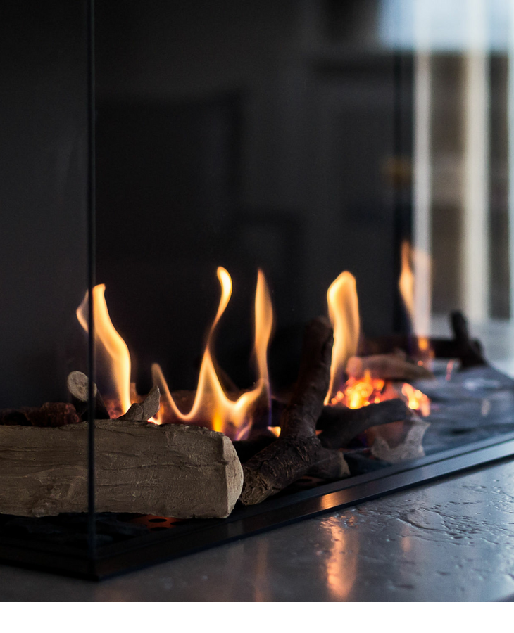 Moderner Gaskamin mit sichtbaren Flammen hinter Glas im Landhaus Severin*s Morsum Kliff auf Sylt.