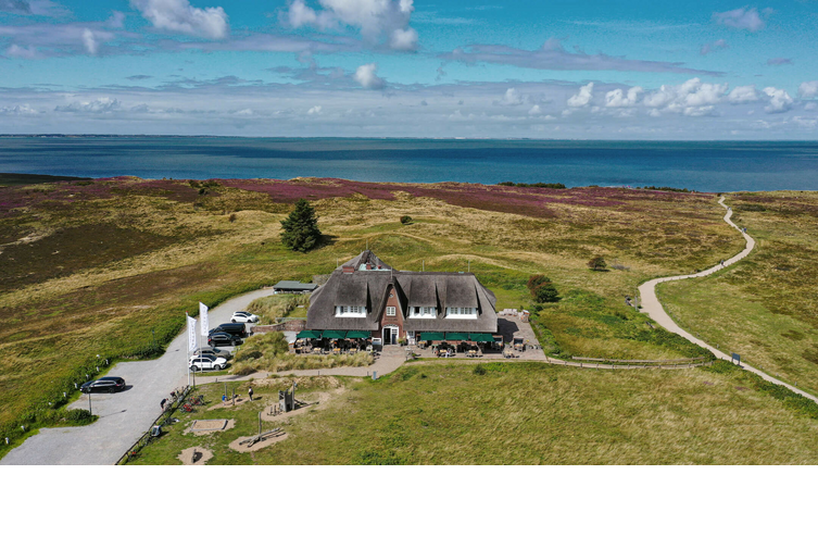 Luftaufnahme des Landhaus Severin*s Morsum Kliff auf Sylt, umgeben von Heide und Meerblick.