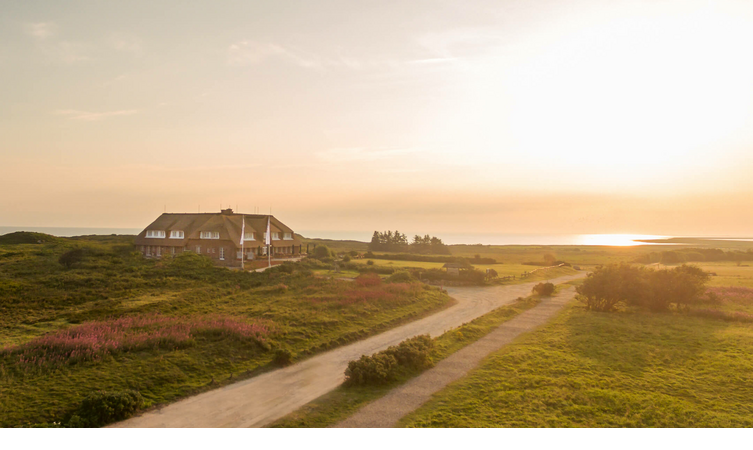 Landhaus Severin*s Morsum Kliff bei Sonnenaufgang Landhaus Severin*s Morsum Kliff auf Sylt in der Abenddämmerung, umgeben von grüner Landschaft und einem Sonnenuntergang.