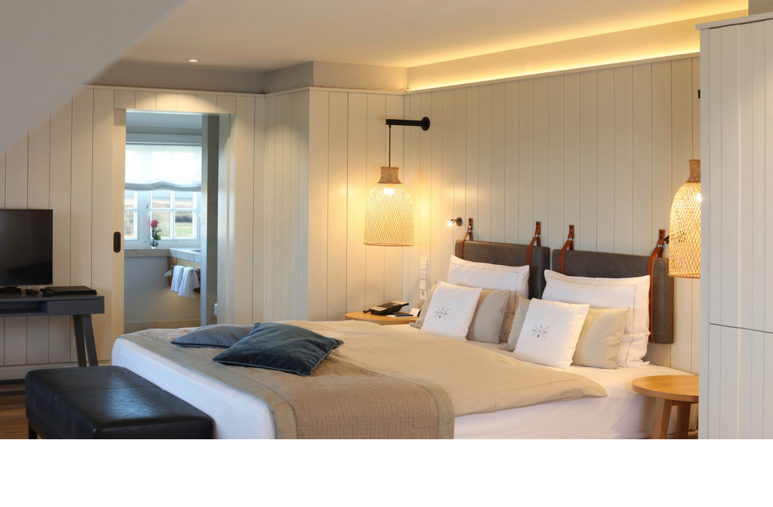 Gemütliches Hotelzimmer im Landhausstil mit Doppelbett, TV, stilvoller Beleuchtung und Fensterblick im Landhaus Severin*s.