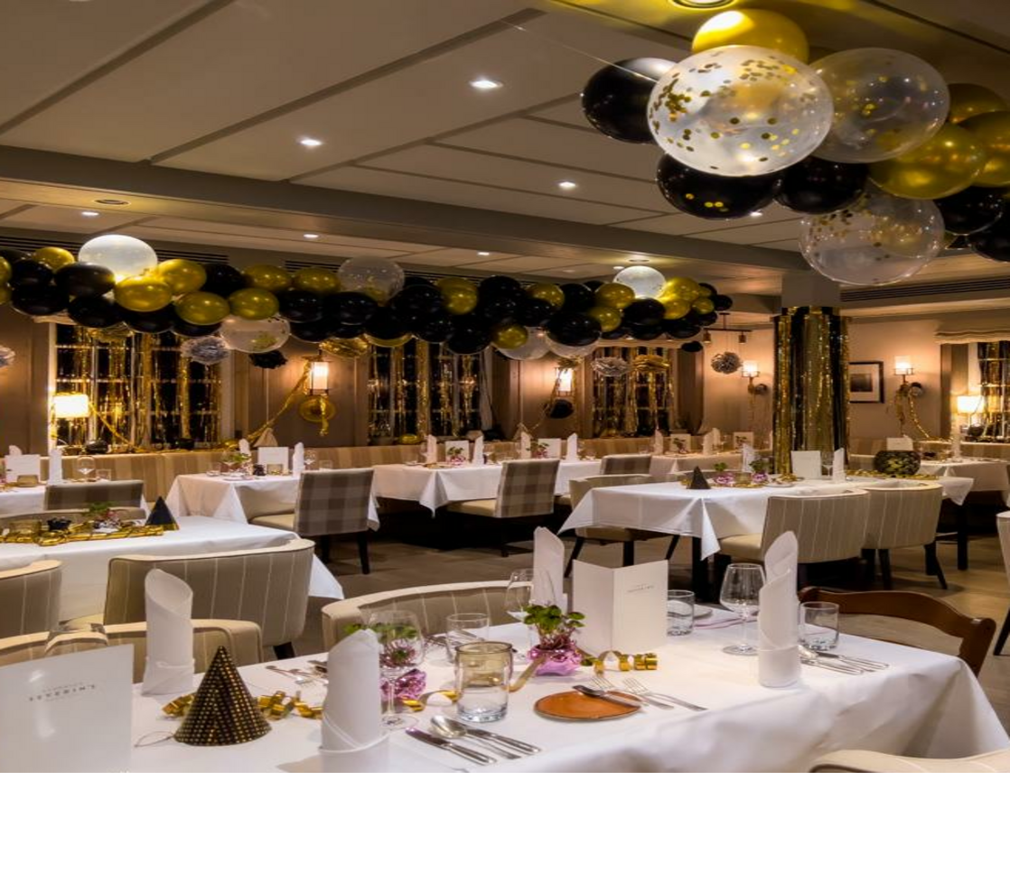 Elegantes Restaurant im Landhaus Severin*s, dekoriert mit gold-schwarzen Luftballons und festlich gedeckten Tischen an Silvester.