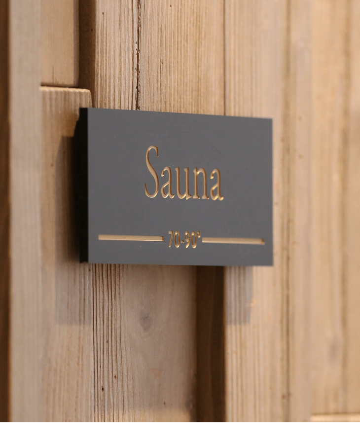 Sauna im Landhaus Severin*s Morsum Kliff auf Sylt Schild mit "Sauna" und Temperaturangabe 70-90 Grad an Holzwand im Landhaus Severin*s Morsum Kliff.
