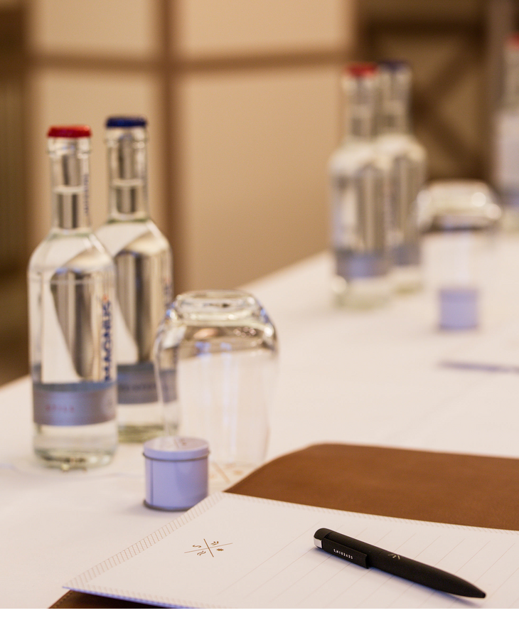 Konferenztisch mit Wasserflaschen, Gläsern, Notizblock und Stift im Severin*s Resort & Spa auf Sylt.