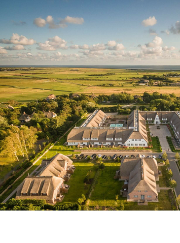 Luftaufnahme des Severin*s Resort & Spa auf Sylt, umgeben von grünen Feldern und idyllischer Landschaft.